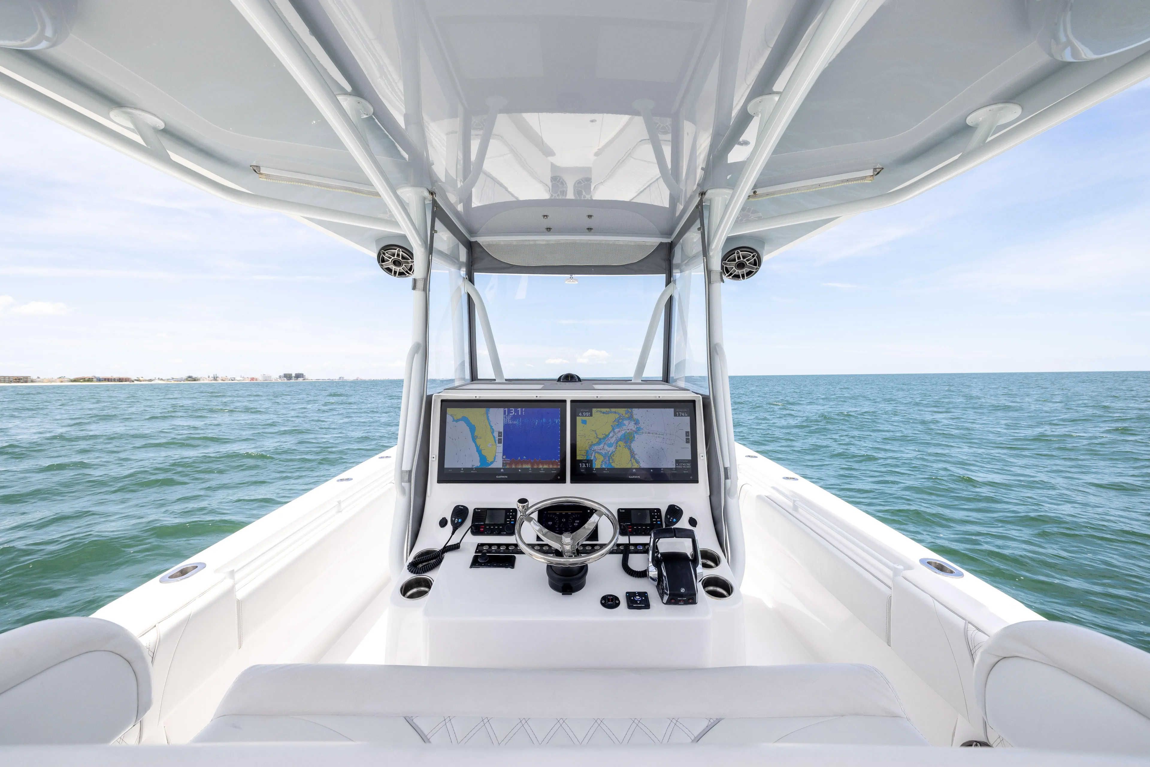  Yacht Photos Pics 2024 Contender 39 ST boat helm with dual navigation screens on open sea.