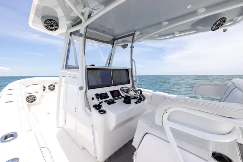  Yacht Photos Pics 2024 Contender 39 ST boat cockpit with dual screens, steering wheel, and ocean view.