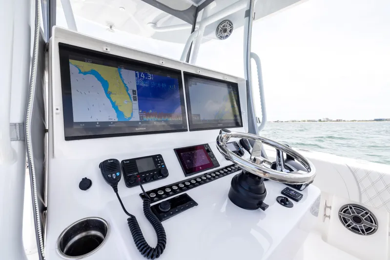  Yacht Photos Pics 2024 Contender 39 ST boat dashboard with navigation screens and steering wheel.