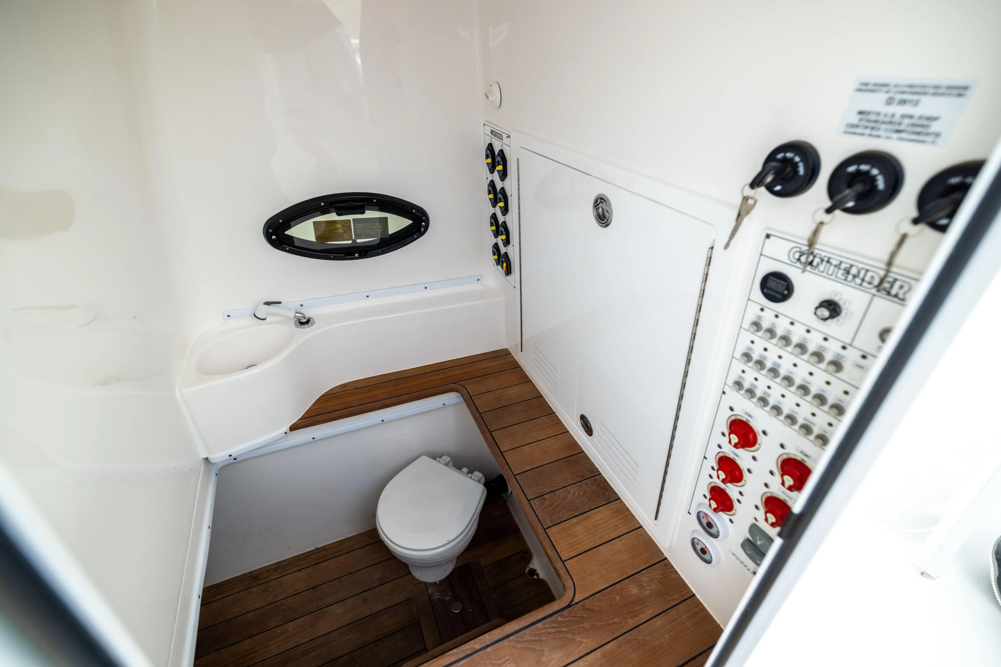 Yacht Photos Pics 2024 Contender 39 ST boat interior with toilet, control panel, and wooden flooring.