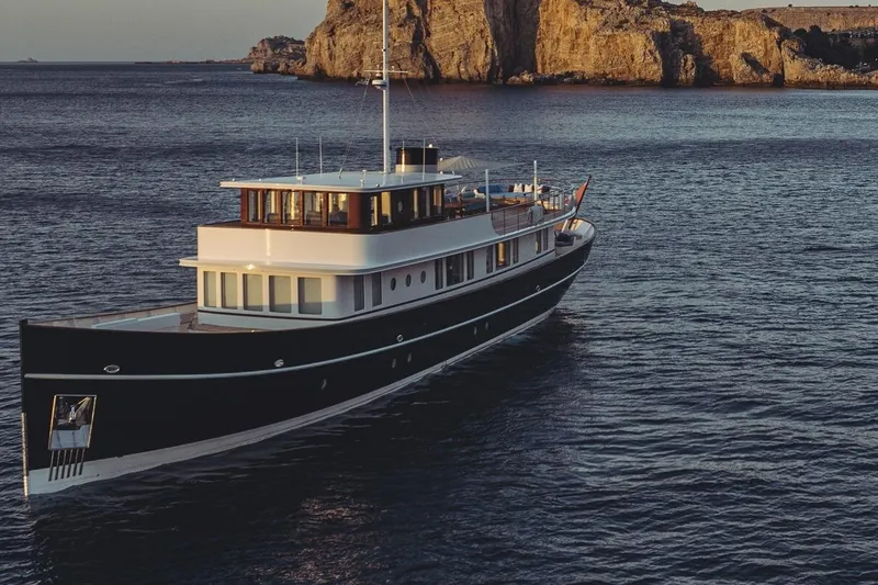 Far Niente Yacht Photos Pics Luxurious 2024 Ses Yachts Hoek Design Modern Classic sailing near rocky coastline.