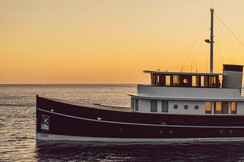 Far Niente Yacht Photos Pics 2024 Hoek Design Custom Modern Classic motor yacht at sunset on the ocean.
