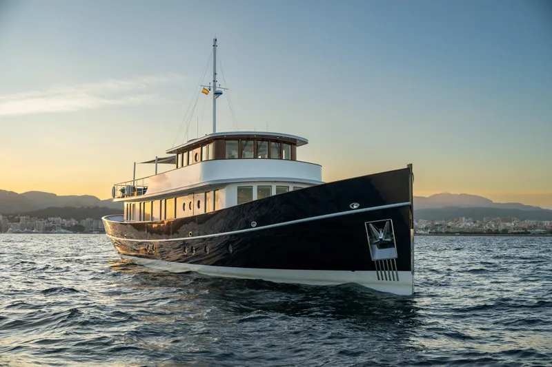 Far Niente Yacht Photos Pics 2024 Ses Yachts Hoek Design Modern Classic yacht on serene waters at sunset.