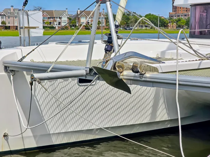 Le Tigre Yacht Photos Pics 2019 Lagoon 42 catamaran anchored near waterfront homes, showcasing sleek design and rigging.
