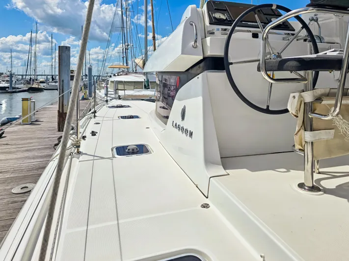Le Tigre Yacht Photos Pics 2019 Lagoon 42 catamaran docked at marina, featuring sleek deck and steering wheel.