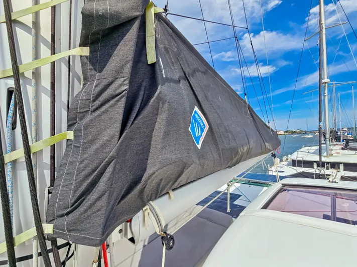 Le Tigre Yacht Photos Pics 2019 Lagoon 42 sailboat with covered sail, docked under a clear blue sky.