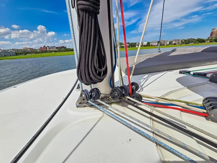Le Tigre Yacht Photos Pics 2019 Lagoon 42 sailboat deck with ropes and pulleys, under a clear blue sky.