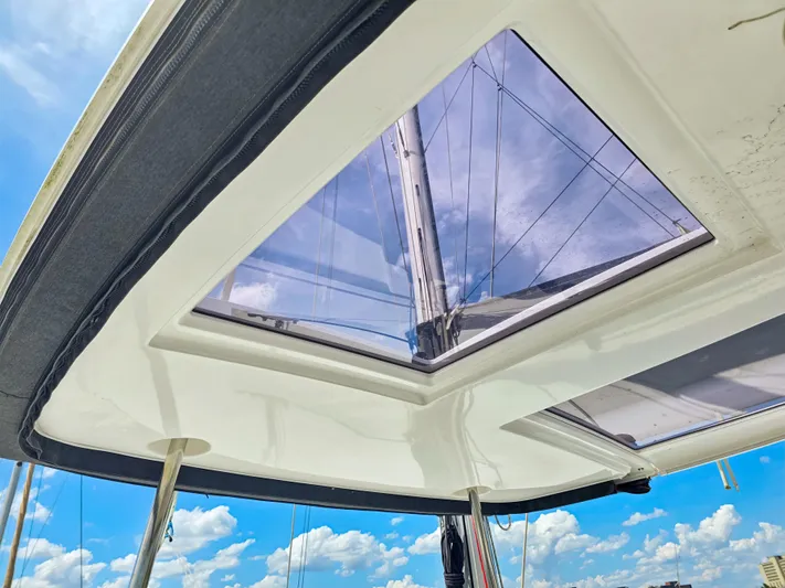 Le Tigre Yacht Photos Pics View through the skylight of a 2019 Lagoon 42 catamaran against a blue sky.