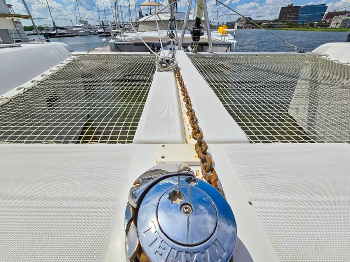 Le Tigre Yacht Photos Pics 2019 Lagoon 42 catamaran deck with anchor chain and netting, docked at marina.