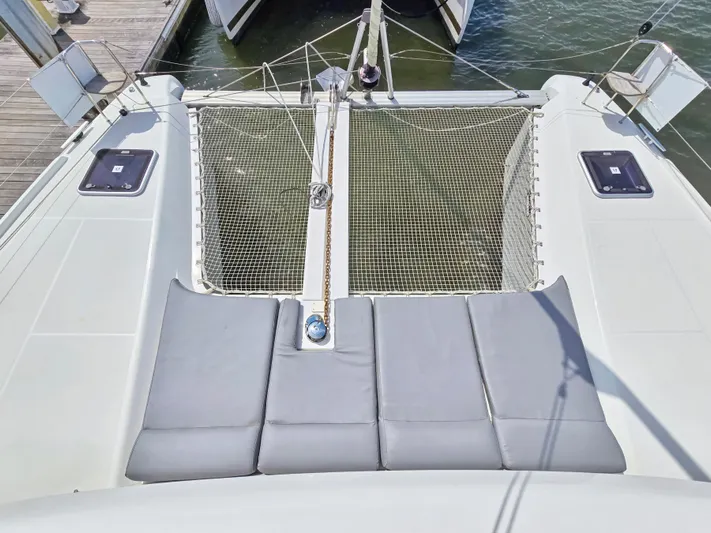Le Tigre Yacht Photos Pics 2019 Lagoon 42 catamaran deck with netting and cushioned seating area.