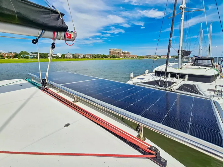 Le Tigre Yacht Photos Pics 2019 Lagoon 42 catamaran with solar panels docked by the water.