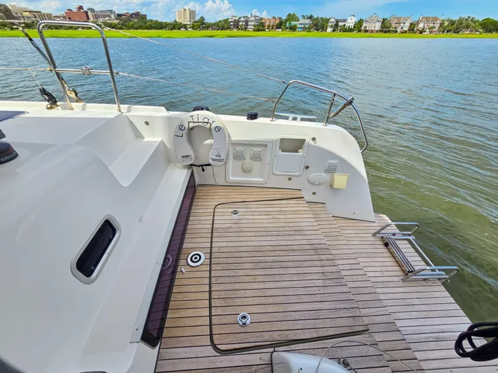 Le Tigre Yacht Photos Pics 2019 Lagoon 42 yacht deck with wooden flooring and scenic waterfront view.
