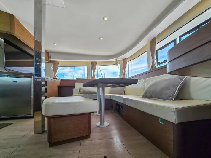Le Tigre Yacht Photos Pics Luxurious interior of 2019 Lagoon 42 catamaran with modern seating and panoramic windows.