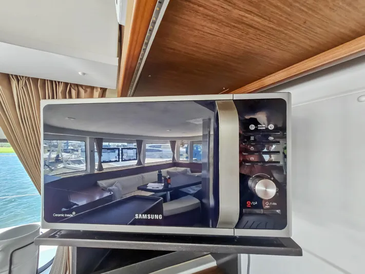 Le Tigre Yacht Photos Pics Microwave on 2019 Lagoon 42 yacht, reflecting interior seating area with windows.