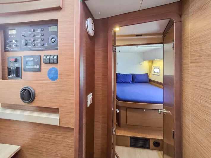 Le Tigre Yacht Photos Pics Interior of 2019 Lagoon 42 yacht showing control panel and cozy cabin with blue bedding.