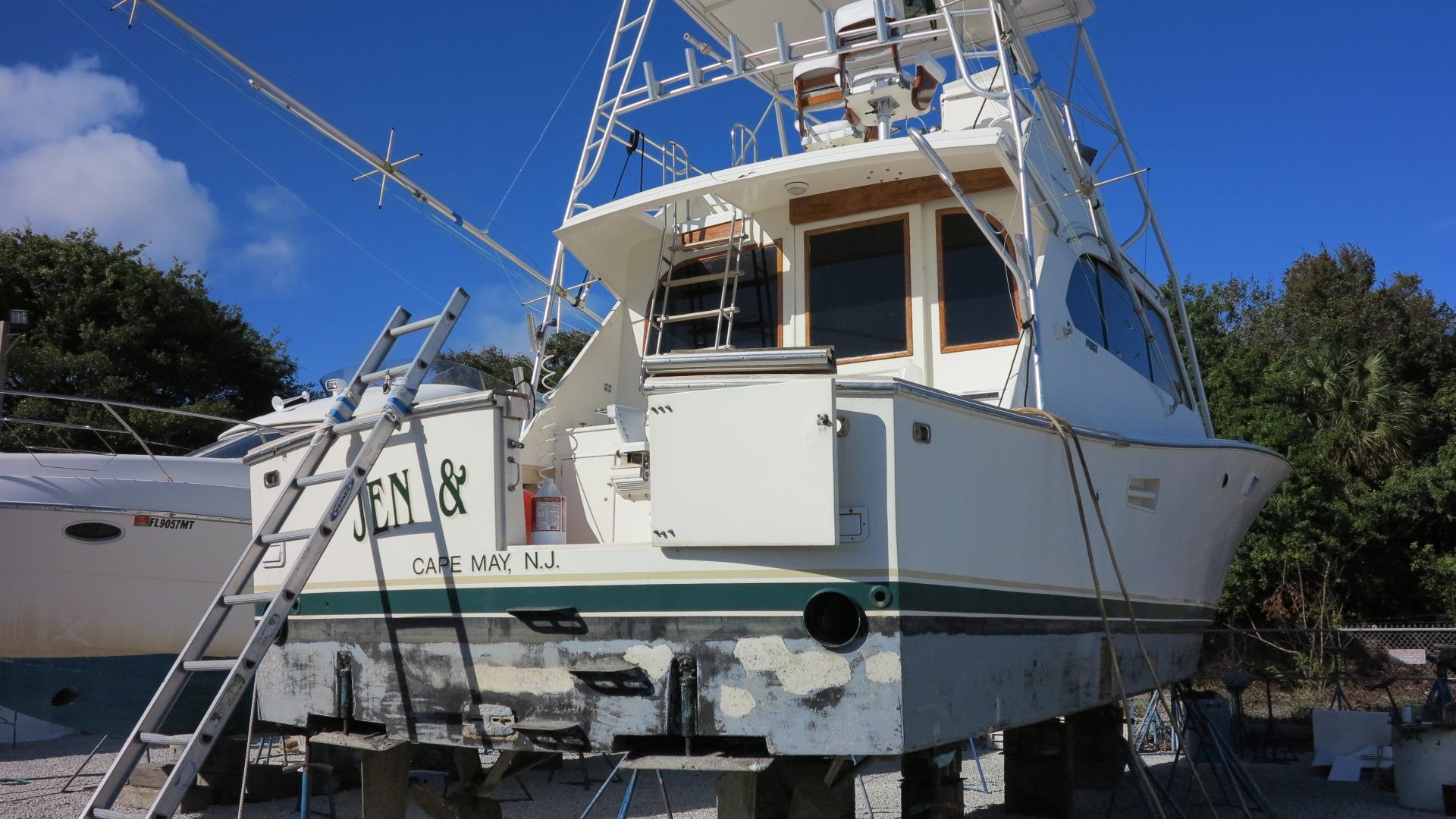 1986 Post Sportfisher boat on land, Cape May, NJ, with clear blue sky.