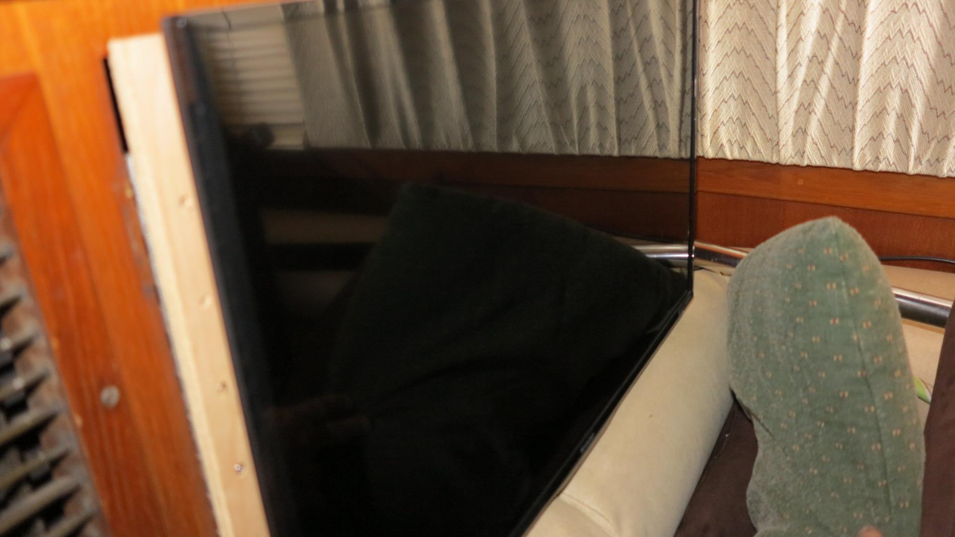 Interior of a 1986 Post Sportfisher boat with a mounted flat-screen TV.