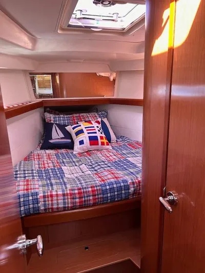 Sapphire Yacht Photos Pics Cozy cabin interior of 2009 Beneteau Oceanis 40 sailboat with nautical-themed bedding.