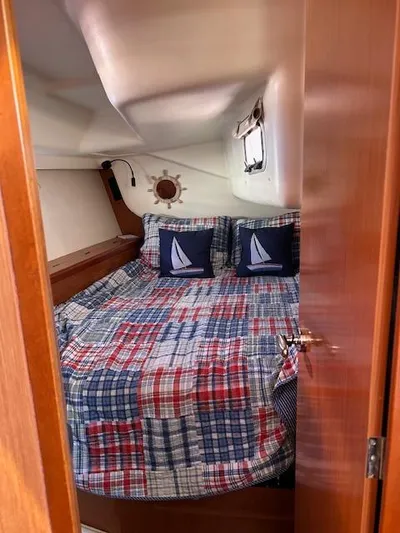 Sapphire Yacht Photos Pics Cozy cabin interior of 2009 Beneteau Oceanis 40 sailboat with nautical-themed bedding.