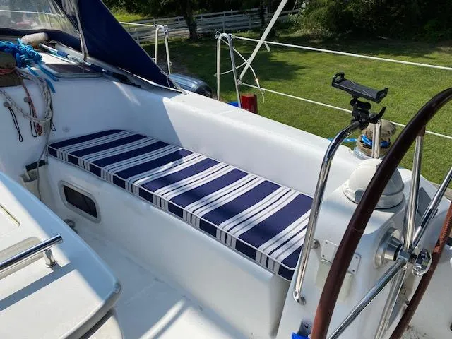 Sapphire Yacht Photos Pics Beneteau Oceanis 40 cockpit with striped cushion, 2009 model, featuring steering wheel and outdoor setting.