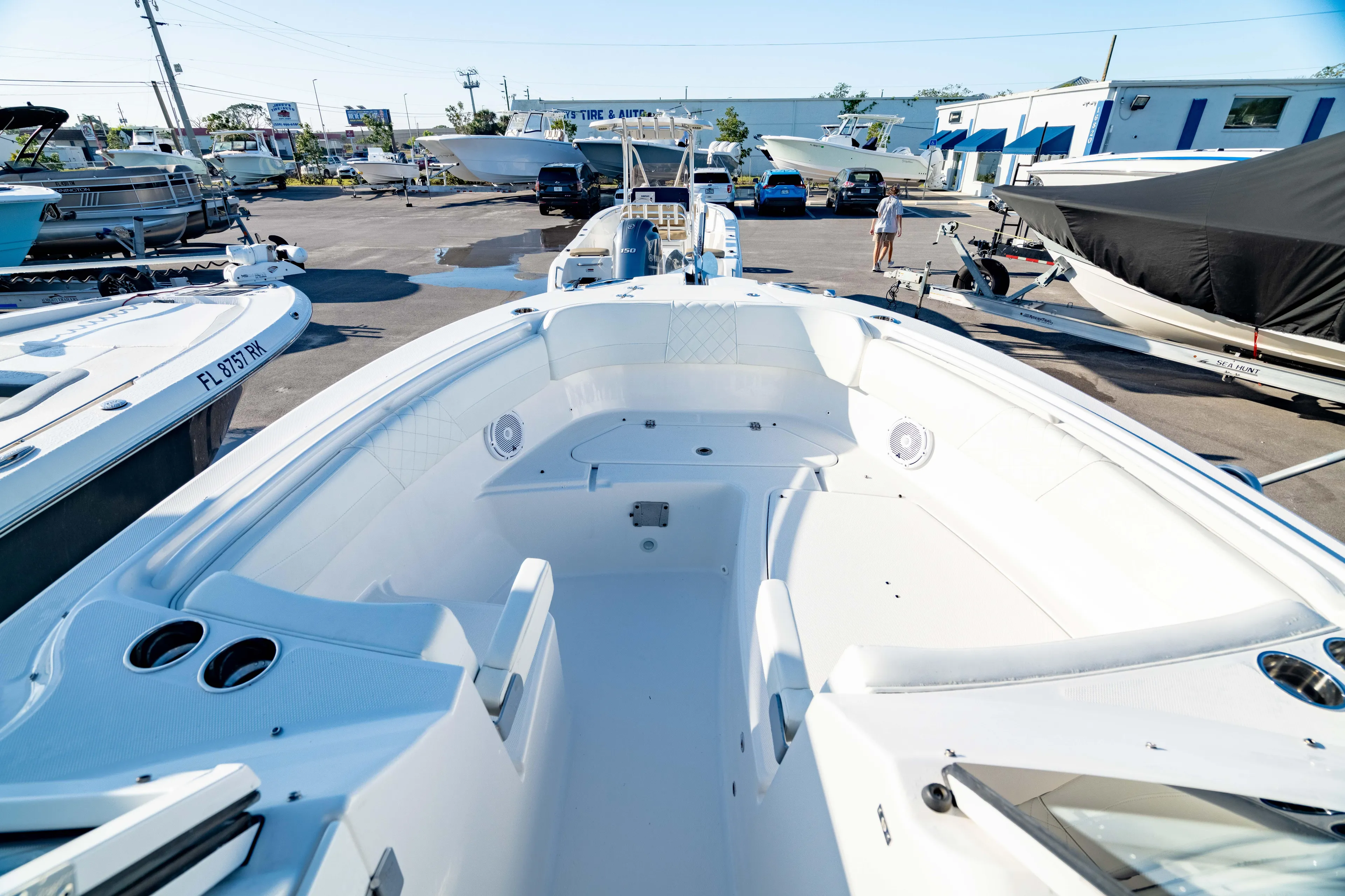  Yacht Photos Pics 2022 Edgewater 262 CX boat interior, spacious seating, parked in a marina with other boats.