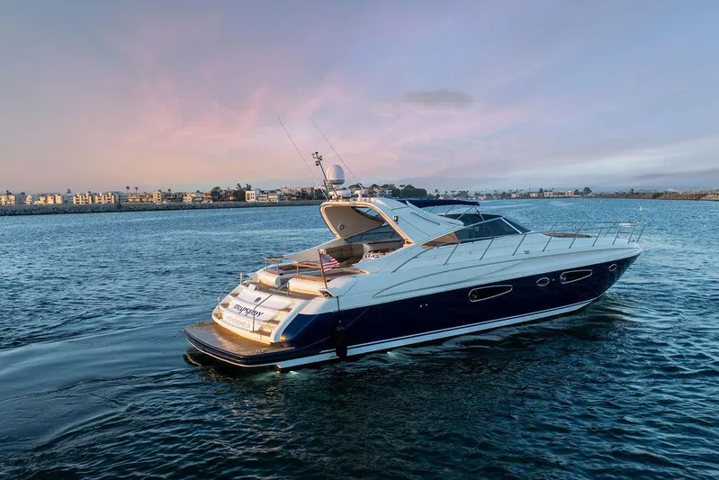 Rhapsody Yacht Photos Pics 2004 Riva 59 Mercurius yacht cruising on serene waters at sunset.