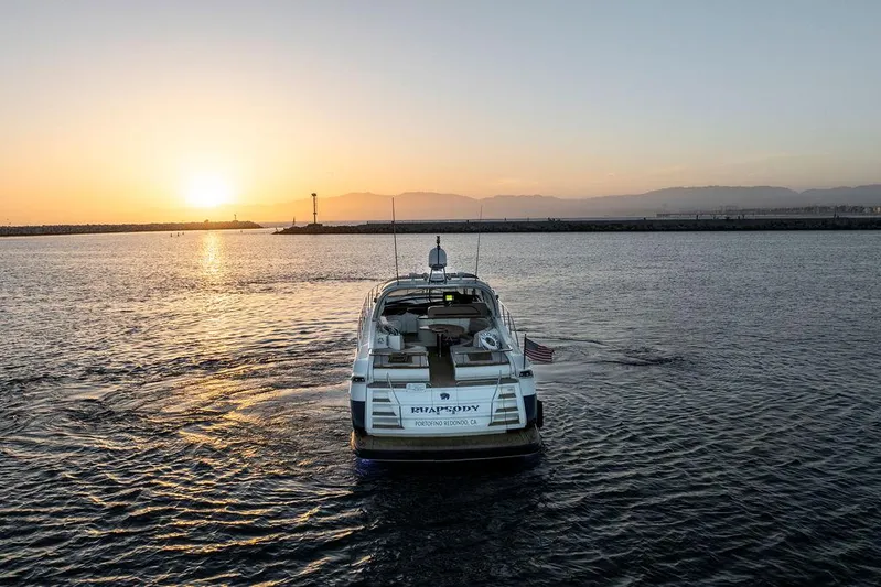 Rhapsody Yacht Photos Pics 2004 Riva 59 Mercurius yacht cruising at sunset on open water.