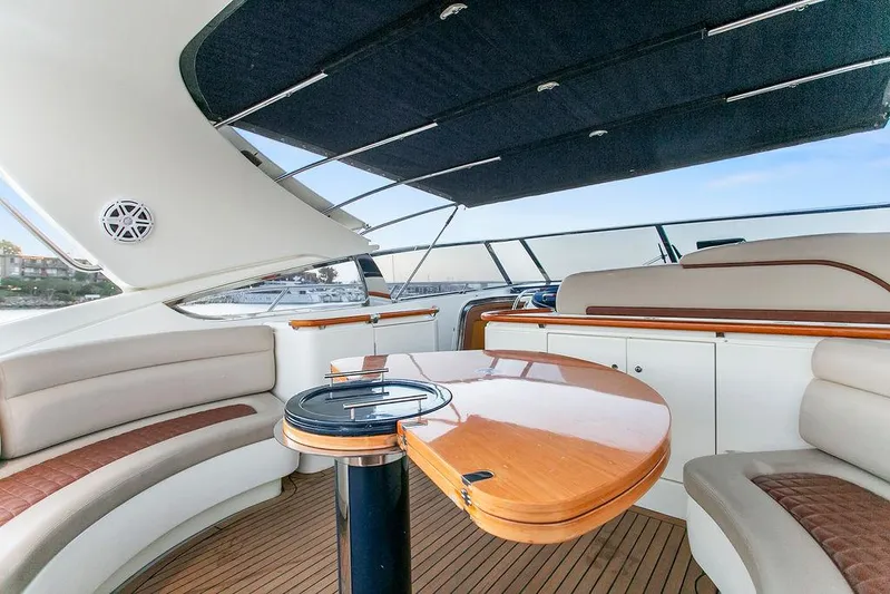 Rhapsody Yacht Photos Pics Luxurious 2004 Riva 59 Mercurius yacht interior with elegant seating and wooden table.