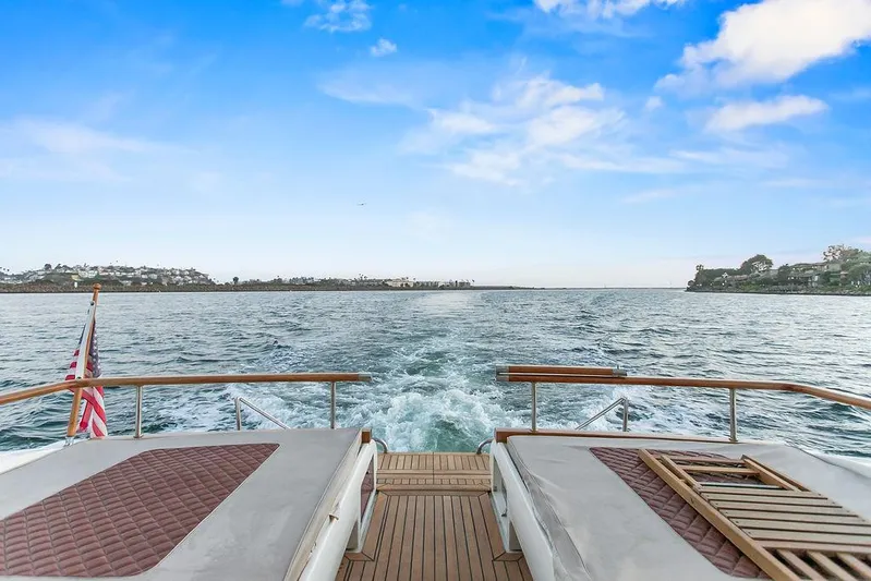Rhapsody Yacht Photos Pics 2004 Riva 59 Mercurius yacht cruising on open water under a clear blue sky.