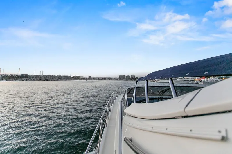Rhapsody Yacht Photos Pics 2004 Riva 59 Mercurius yacht cruising on calm waters under a clear blue sky.