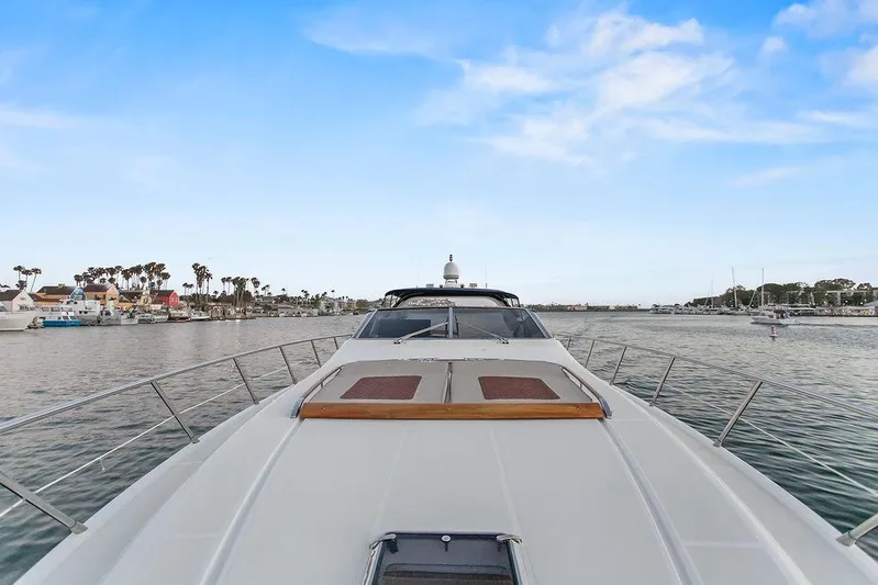 Rhapsody Yacht Photos Pics 2004 Riva 59 Mercurius yacht cruising in a scenic harbor with blue skies.