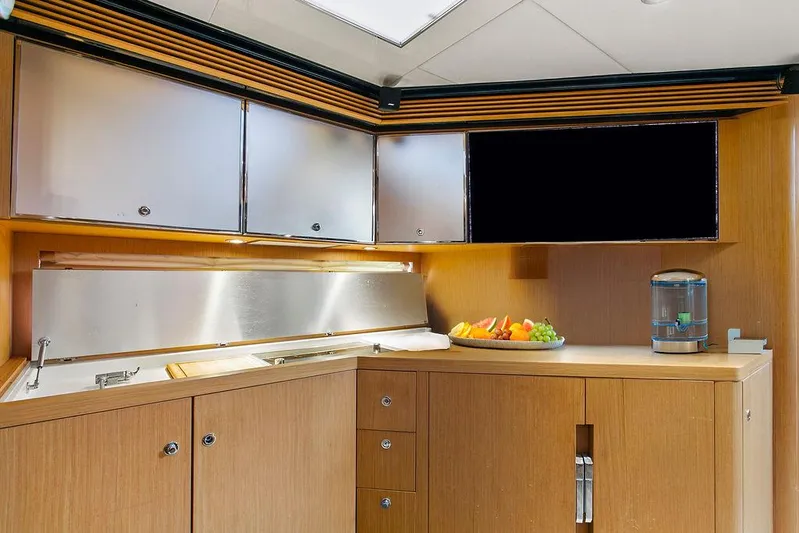 Rhapsody Yacht Photos Pics Luxurious kitchen interior of 2004 Riva 59 Mercurius yacht with modern cabinetry and fruit display.