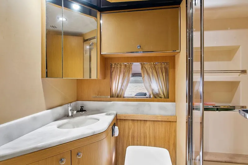 Rhapsody Yacht Photos Pics Luxurious bathroom interior of 2004 Riva 59 Mercurius yacht with modern fixtures and wood accents.