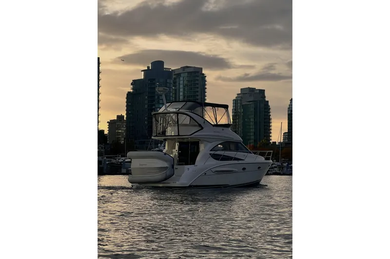 Tangerine Yacht Photos Pics 2009 Meridian 341 Sedan yacht on water at sunset with city skyline backdrop.