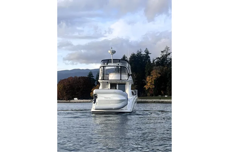 Tangerine Yacht Photos Pics 2009 Meridian 341 Sedan yacht on calm water with scenic forest backdrop.