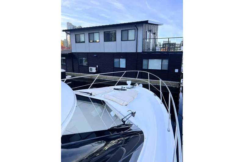 Tangerine Yacht Photos Pics 2009 Meridian 341 Sedan yacht docked near modern houseboat.