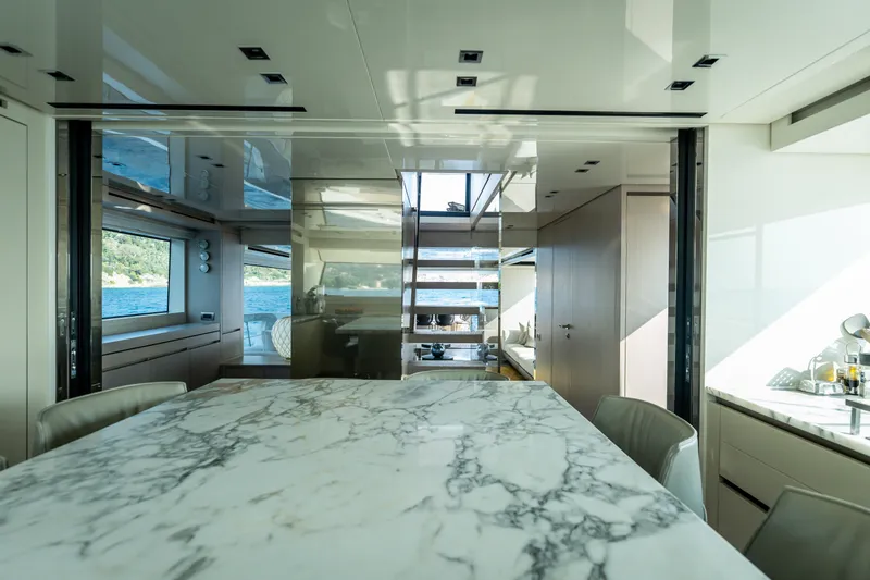 La Yacht Photos Pics Luxurious interior of 2022 Sanlorenzo SX88 yacht with marble table and scenic window views.