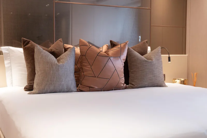 La Yacht Photos Pics Luxurious bedroom interior on 2022 Sanlorenzo SX88 yacht with elegant pillows and modern decor.