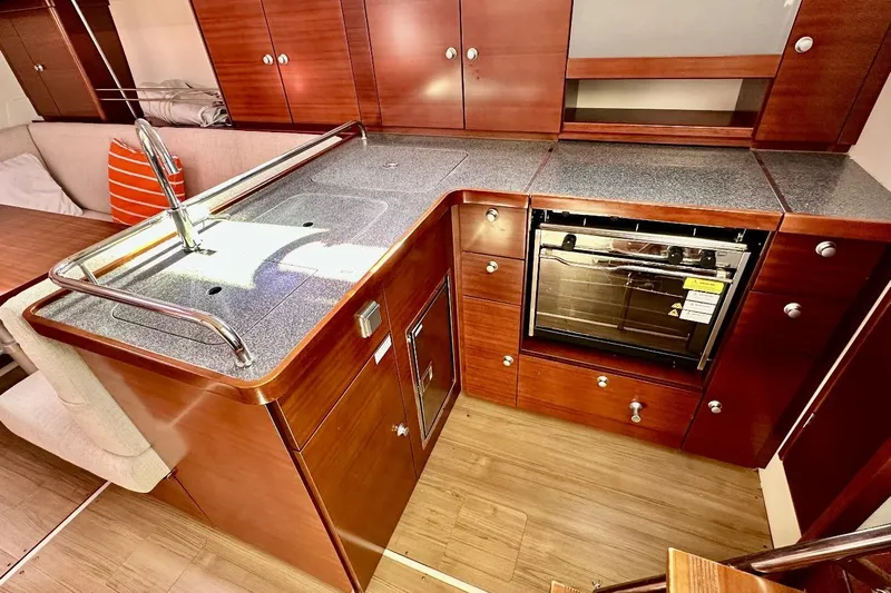 Yacht Photos Pics 2008 Hanse 370e yacht kitchen with wooden cabinets, stainless steel sink, and built-in oven.
