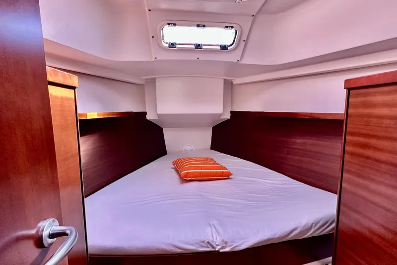  Yacht Photos Pics Cozy cabin interior of 2008 Hanse 370e sailboat with wooden finish and bed.