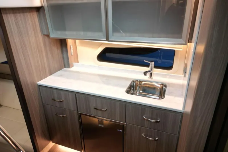  Yacht Photos Pics Modern galley kitchen in 2023 Regal 42 Fly yacht with sleek cabinetry and stainless steel sink.