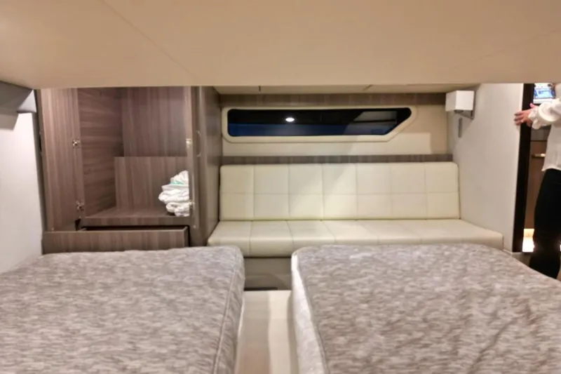  Yacht Photos Pics 2023 Regal 42 Fly yacht interior with twin beds, sofa, and wooden cabinetry.