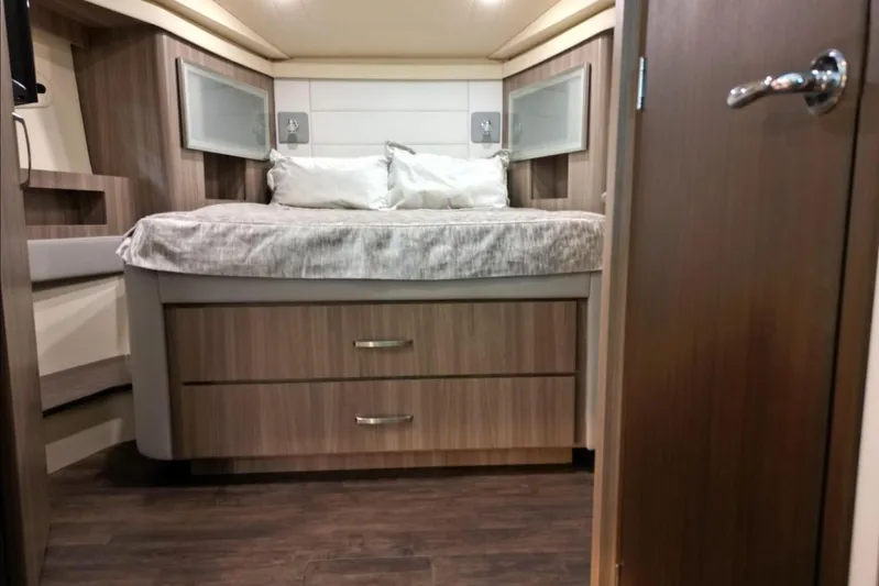  Yacht Photos Pics 2023 Regal 42 Fly yacht interior bedroom with modern wood finish and cozy bedding.