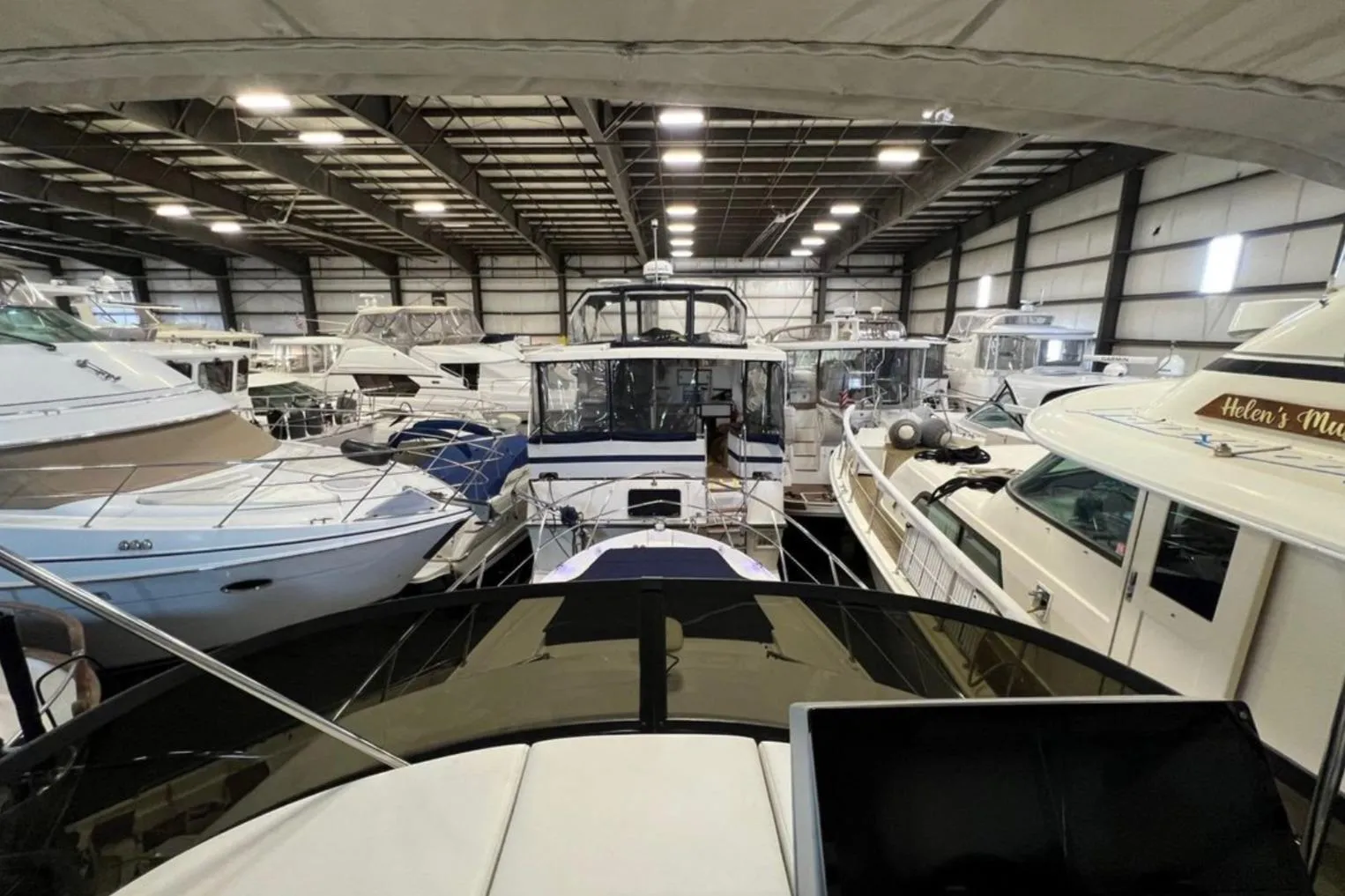Indoor marina with multiple yachts, featuring a 2023 Regal 42 Fly model.