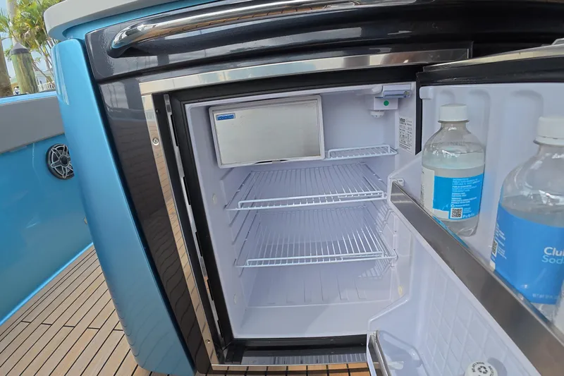  Yacht Photos Pics Open mini fridge on Schaefer V44 yacht, showcasing interior shelves and bottled drinks.