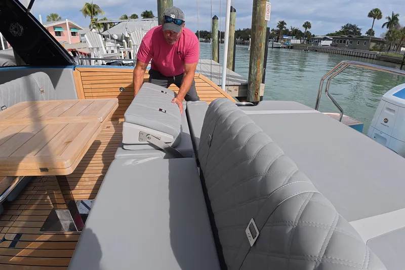  Yacht Photos Pics 2025 Schaefer V44 yacht with adjustable seating and wooden table, docked by the water.