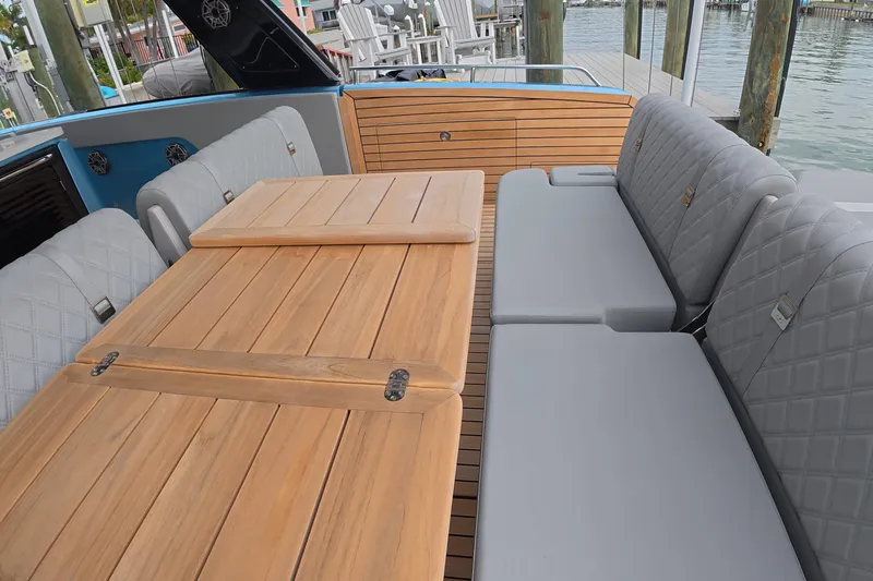  Yacht Photos Pics Luxurious seating area on 2025 Schaefer V44 yacht with wooden table and cushioned benches.