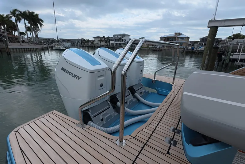  Yacht Photos Pics 2025 Schaefer V44 yacht with dual Mercury outboard engines docked by waterfront homes.