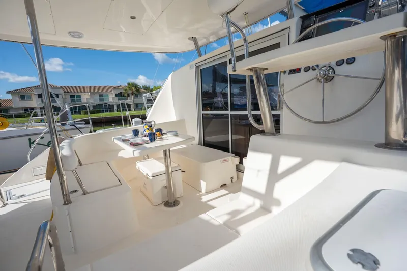 Lovely Cruise Yacht Photos Pics Leopard 38 catamaran cockpit, 2011 model, featuring seating and helm, docked near waterfront homes.