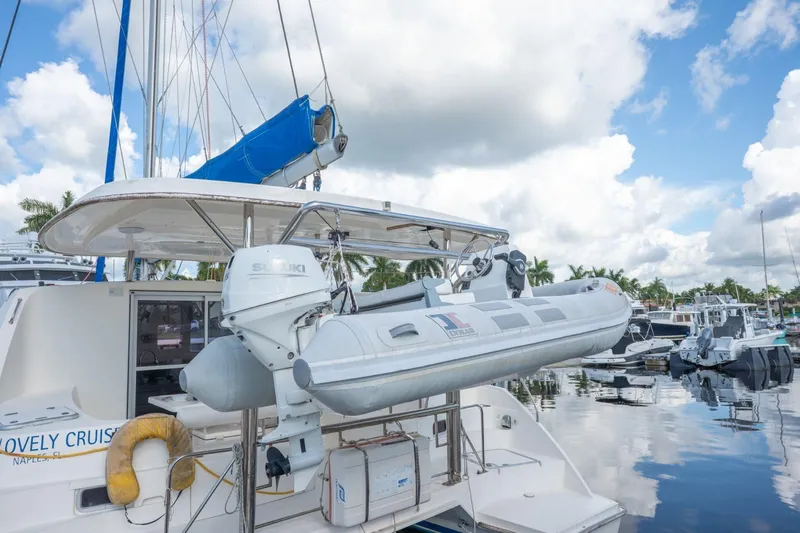 Lovely Cruise Yacht Photos Pics 2011 Leopard 38 catamaran with dinghy and Suzuki outboard motor in a marina setting.